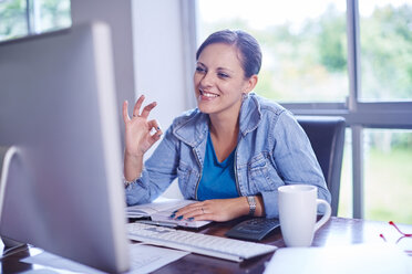 Smiling woman working at desk - ZEF002313