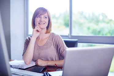 Smiling woman at desk - ZEF002318