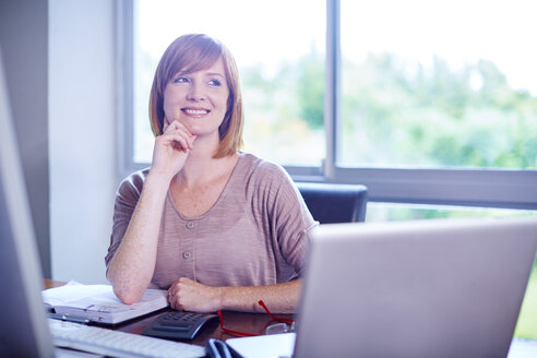 Smiling woman at desk - ZEF002318