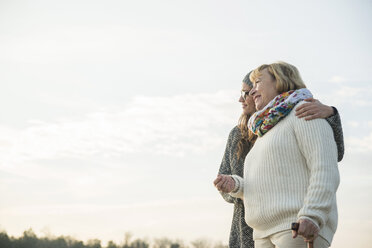 Young woman and her grandmother watching sunset - UUF002618