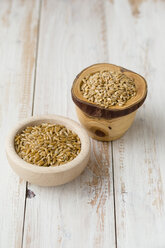 Bowl of polish wheat and bowl of Einkorn wheat, Triticum monococcum, on light wood - MYF000690