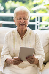 Porträt einer älteren Frau mit digitalem Tablet - ABAF001577