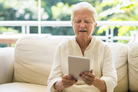 Porträt einer älteren Frau mit digitalem Tablet, lizenzfreies Stockfoto