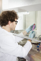Labortechniker bei der Arbeit mit einem Reagenzglas im Labor - FKF000881
