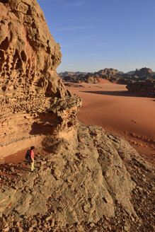 Algeria, Tassili n' Ajjer, Tadrart, Sahara, Tassili n' Ajjer National Park, woman hiking in the rocky landscape of the cirque - ES001457