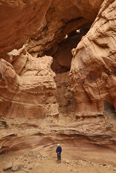 Algerien, Sahara, Tassili N'Ajjer National Park, Tadrart Region, Tisseteka, Mann steht in einem riesigen Schlagloch - ES001459