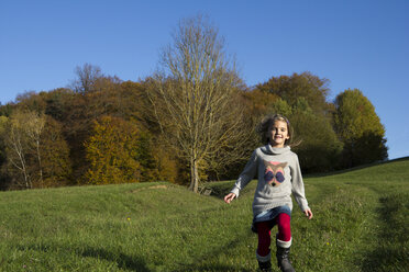 Germany, Bavaria, Landshut, girl running on meadow in autumn - YFF000258