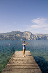 Italien, Venetien, Brenzone sul Garda, Junge fotografiert mit Smartphone - LVF002164