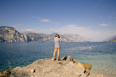 Italien, Venetien, Brenzone sul Garda, Junge fotografiert mit Smartphone - LVF002162