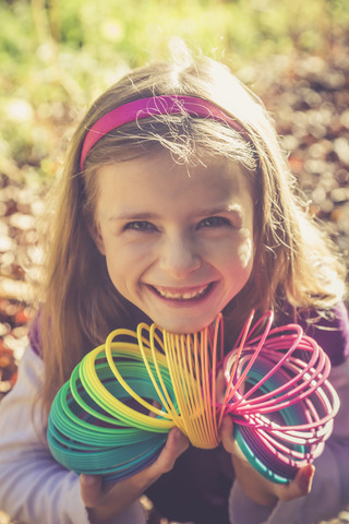 Porträt eines lächelnden kleinen Mädchens mit Spirale in prismatischen Farben, lizenzfreies Stockfoto