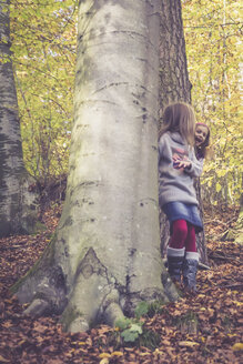 Zwei kleine Mädchen spielen im Wald Verstecken - SARF001019