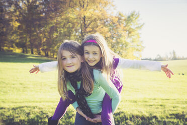 Girl giving another little girl a piggyback - SARF001009