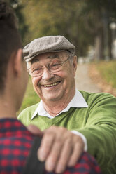 Senior man smiling at adult grandson - UUF002639