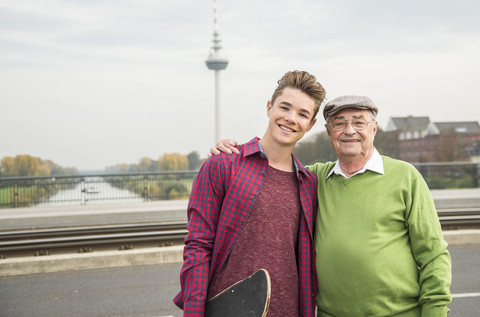 Porträt eines älteren Mannes und eines erwachsenen Enkels im Freien, lizenzfreies Stockfoto