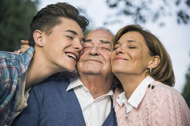 Lächelnder älterer Mann mit Tochter und Enkelkind im Park - UUF002674