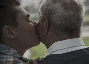 Grandson kissing senior man's cheek - UUF002727