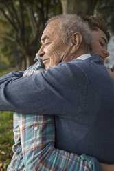 Grandson and senior man hugging - UUF002679