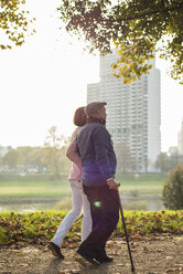 Daughter and senior man walking by the riverside - UUF002691