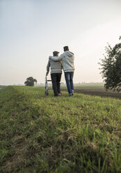 Älterer Mann und Enkel in ländlicher Landschaft mit Rollator - UUF002707