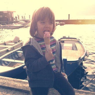 Italien, Malcesine, Mädchen isst Eis am Hafen - LVF002225