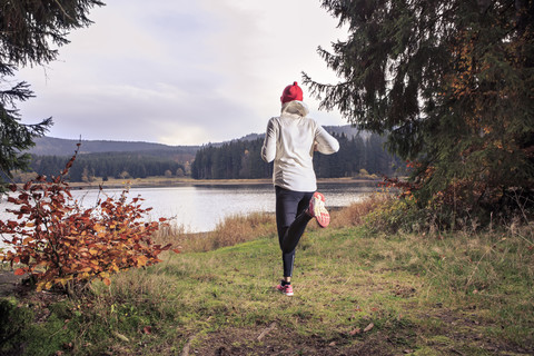 Deutschland, Thüringen, Frau läuft durch den Wald am See bei Alsbach, lizenzfreies Stockfoto