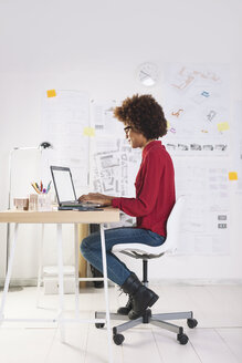 Junge Architektin mit Laptop in ihrem Büro - EBSF000349