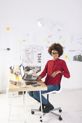 Junge Architektin mit Laptop an ihrem Schreibtisch - EBSF000350