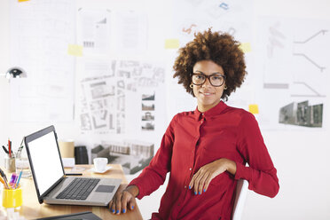 Young female architect with laptop at her desk - EBSF000351