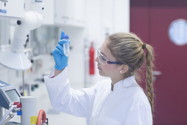 Young female scientist working in a pharmacy research laboratory - SGF001039