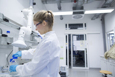 Young female scientist working in a pharmacy research laboratory - SGF001041