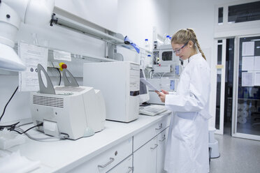 Young female scientist working in a pharmacy research laboratory - SGF001052