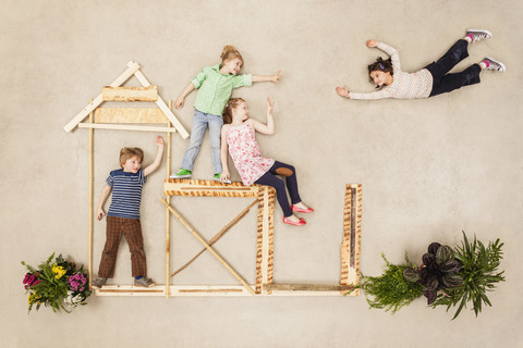 Kinder spielen im Freien und bauen Holzhütten, lizenzfreies Stockfoto