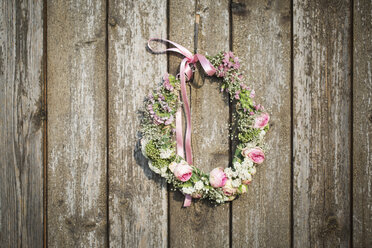 Selbstgemachter Blumenkranz mit Rosenblüten und Schleierkraut an einer Holzwand - ASCF000009