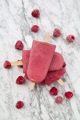 Raspberry ice lollies and frozen raspberries on marble - LVF002209