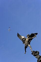 UK, London, Piccadilly Circus, Flugzeug fliegt über die Eros-Skulptur - MIZF000675
