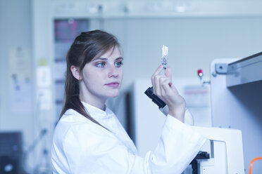 Porträt einer jungen Naturwissenschaftlerin bei der Arbeit in einem mikrobiologischen Labor - SGF001018