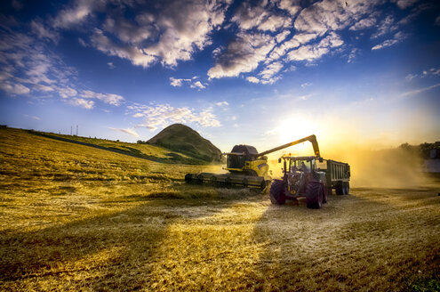 Vereinigtes Königreich, Schottland, East Lothian, North Berwick, Feld, Mähdrescher und Traktor bei Sonnenuntergang - SMA000260