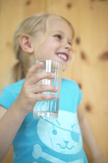 Glückliches blondes Mädchen hält ein Glas Wasser - FSF000347