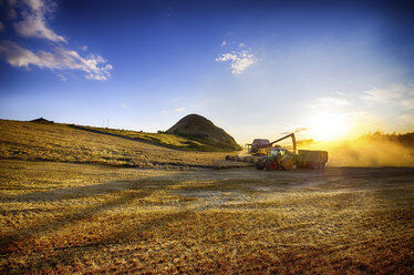 Vereinigtes Königreich, Schottland, East Lothian, North Berwick, Feld, Mähdrescher und Traktor bei Sonnenuntergang - SMA000261