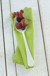 Spoon of different berries on cloth and white wood - ASF005492