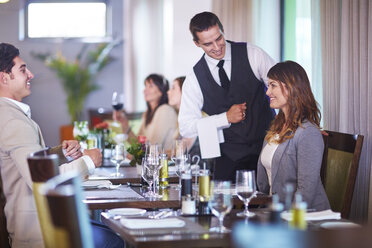 Business people placing an order with waiter at hotel restaurant - ZEF002489