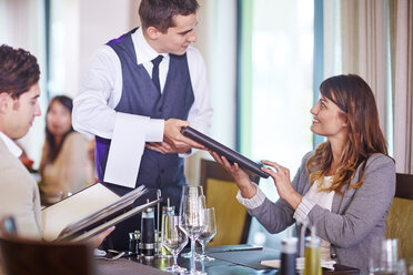 Business people placing an order with waiter at hotel restaurant - ZEF002490