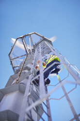 Ingenieur einer Windkraftanlage klettert auf eine Leiter - ZEF002256