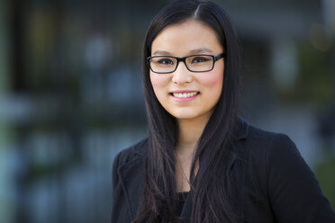 Portrait of smiling young businesswoman wearing glasses - MAD000105