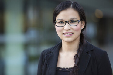 Portrait of smiling young businesswoman wearing glasses - MAD000108