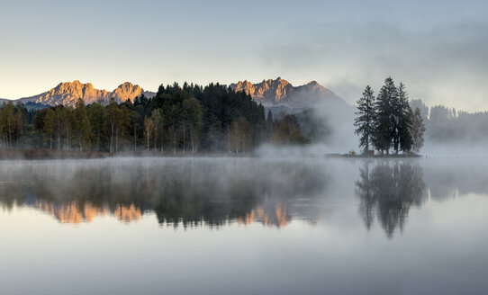 Österreich, Tirol, Kitzbühel, Blick auf den Schwarzsee mit Morgennebel und Kitzbüheler Alpen im Hintergrund - MKFF000143