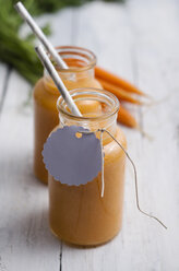 Two glasses of carrot smoothie on white wood - ODF000870