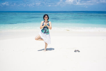 Malediven, Ari Atoll, junge Frau bei Yoga-Übungen am Strand - FLF000573