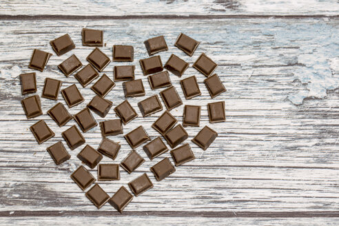 Aus Schokoladenstücken geformtes Herz auf Holz - SARF001047