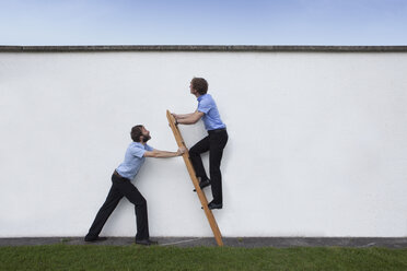 Businessman holding career ladder for colleague - RBF002227